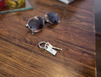 USB-Compact muistitikku avainrenkaassa, ruskealla pöydällä